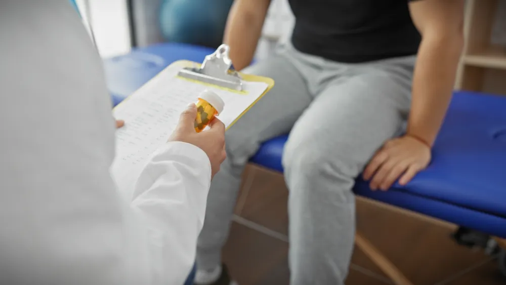 Doctor holding medication while discussing treatment options