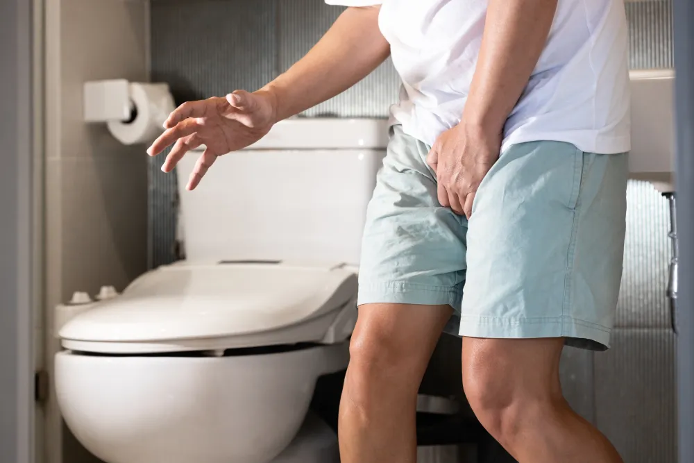 Man holding his pelvic area and appearing to be in discomfort